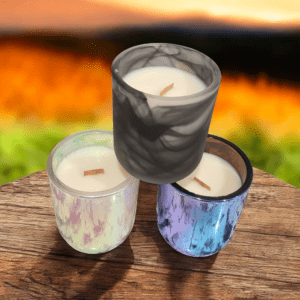 Three candles on wooden surface, scenic background.