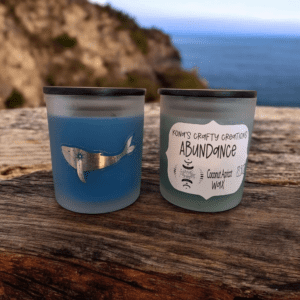 Two candles on weathered wooden surface.