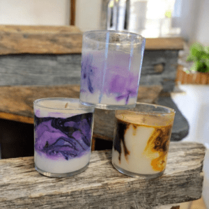 Three colorful marbled candles on wood.