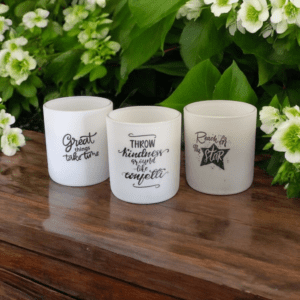 Candles with inspirational quotes on wooden surface.