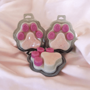 Pink paw-shaped wax melts on fabric.