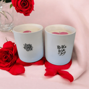 Candles with roses on pink cloth.